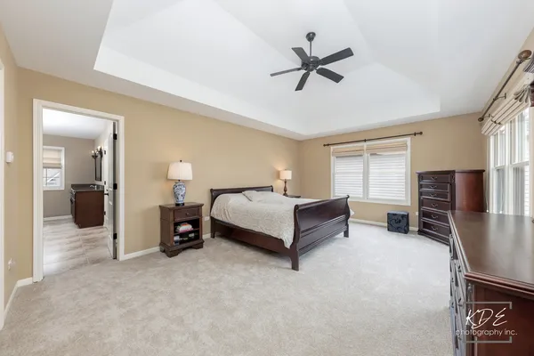 a spacious bedroom with a bed and a ceiling fan