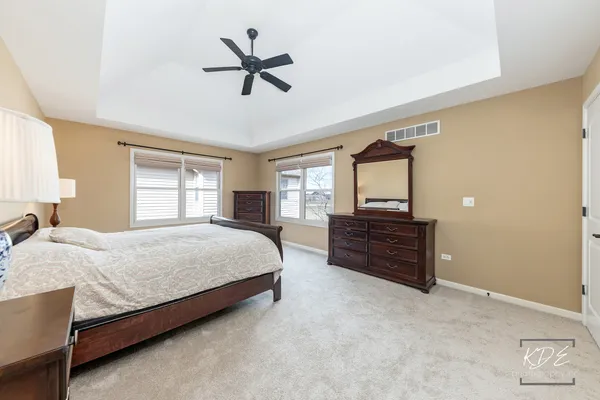 a spacious bedroom with a bed a dresser and a window