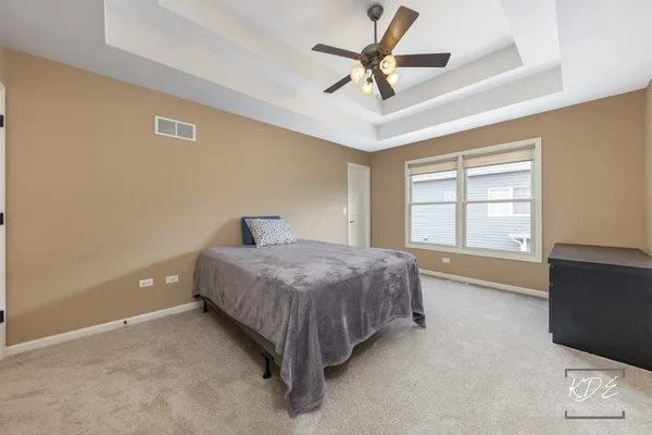 a spacious bedroom with a bed and a ceiling fan