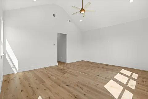 an empty room with a window and ceiling fan