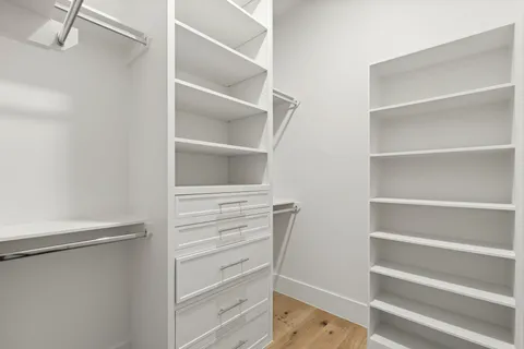 a view of walk in closet with empty racks