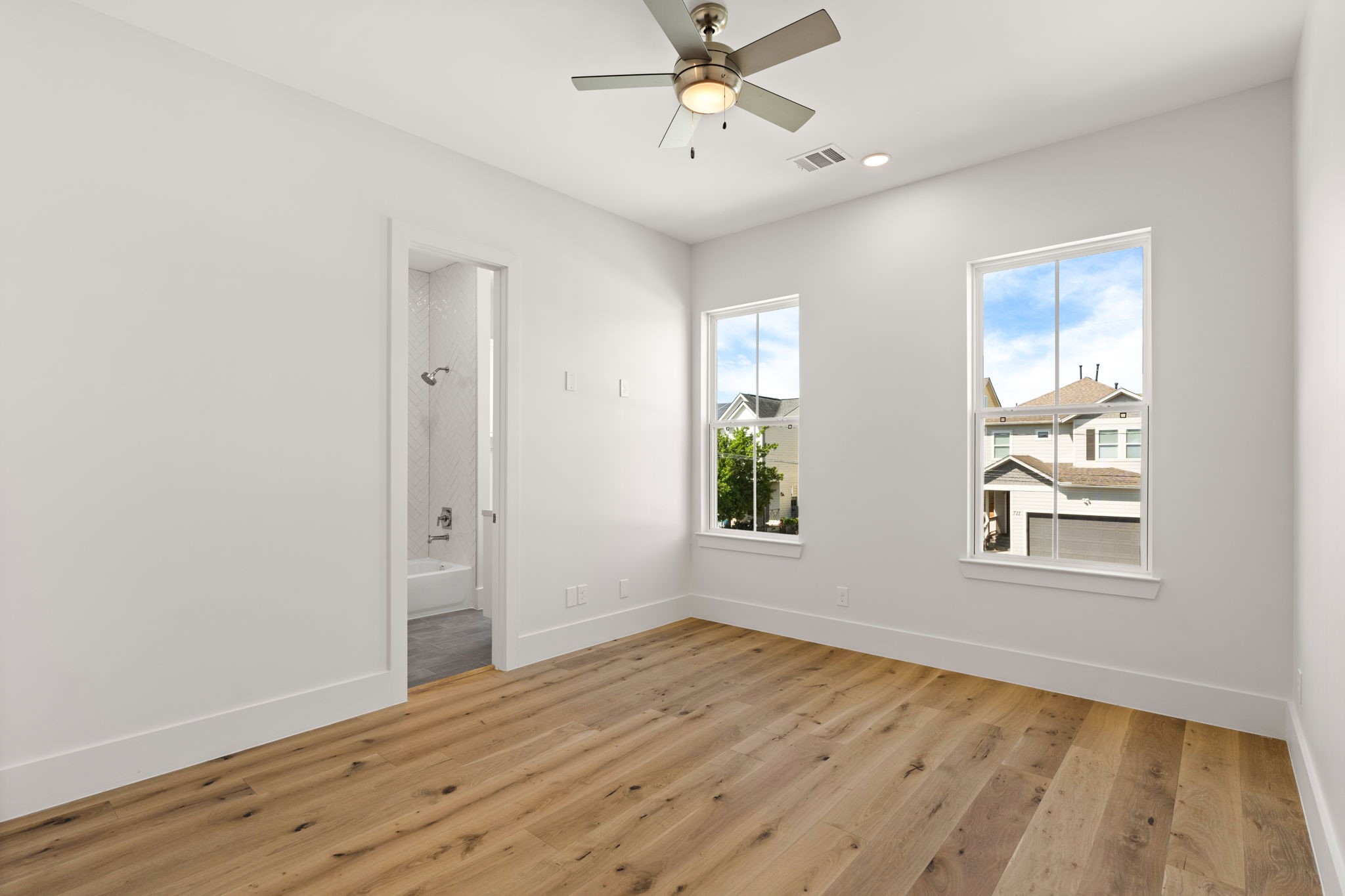 710 Waverly Street, Unit E Houston, TX 77007 - Photo 17 of 19 a view of an empty room with wooden floor and a window