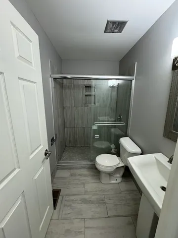 a bathroom with a toilet and a shower