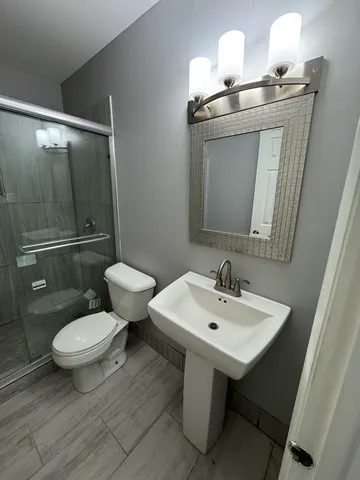 a bathroom with a toilet sink and mirror