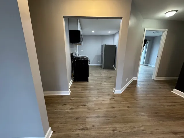 a view of a hallway with wooden floor