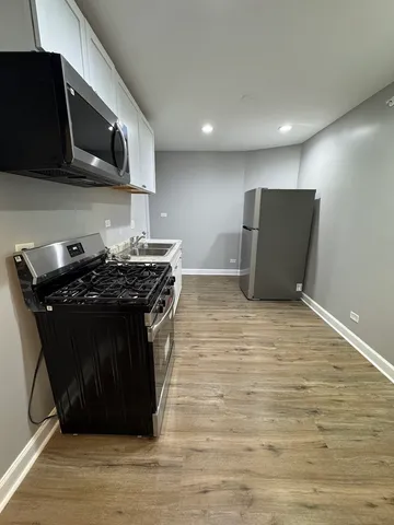 a kitchen with stainless steel appliances wooden cabinets and a stove top oven