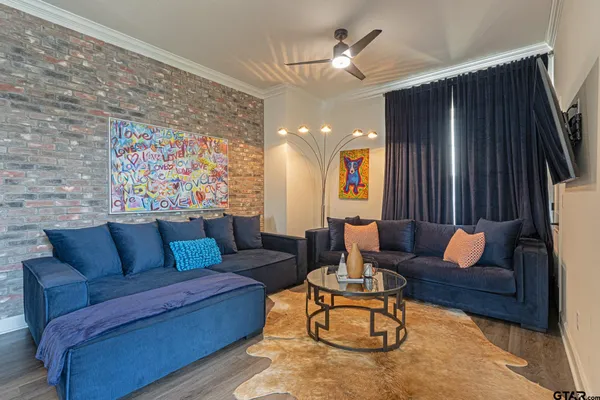 a living room with furniture a flat screen tv and kitchen view