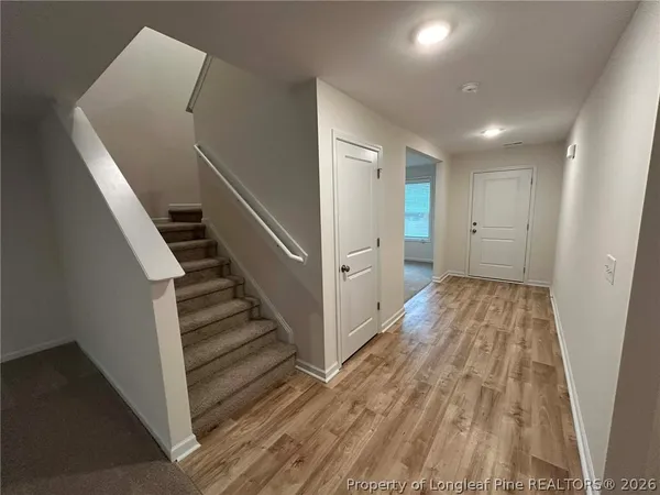 a view of a hallway with wooden floor and staircase