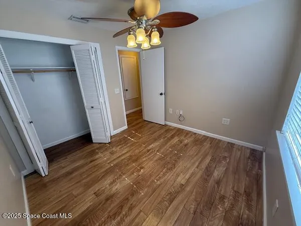 a view of empty room with wooden floor