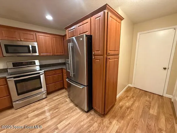 a kitchen with wooden cabinets and stainless steel appliances