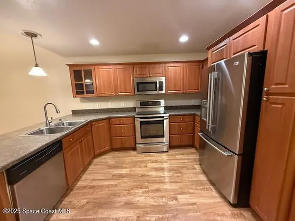 a kitchen with granite countertop a refrigerator and a sink