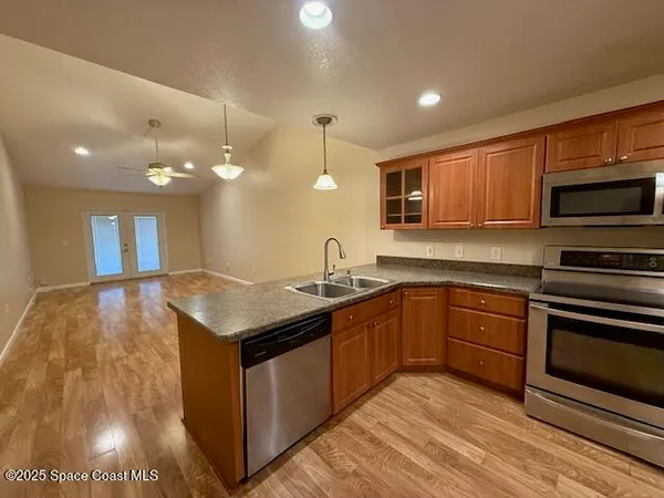 a kitchen with stainless steel appliances granite countertop a sink a stove and a microwave oven