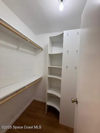 a view of walk in closet with empty racks