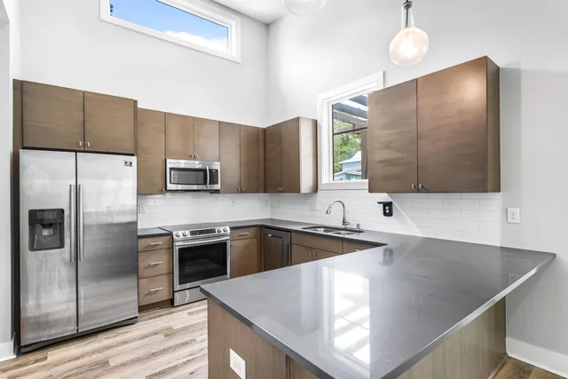 a kitchen with stainless steel appliances granite countertop a sink a stove and refrigerator