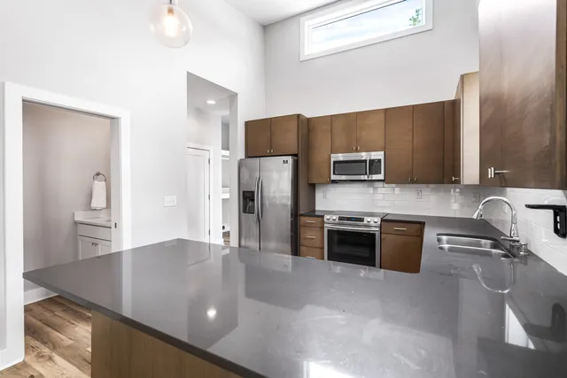 a kitchen with stainless steel appliances granite countertop a sink refrigerator and microwave