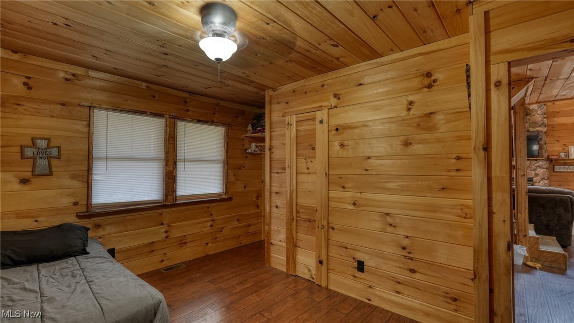 8498 Euga Road Newcomerstown, OH 43832 - Photo 13 of 49 Bedroom with wooden walls, wood-type flooring, and wooden ceiling