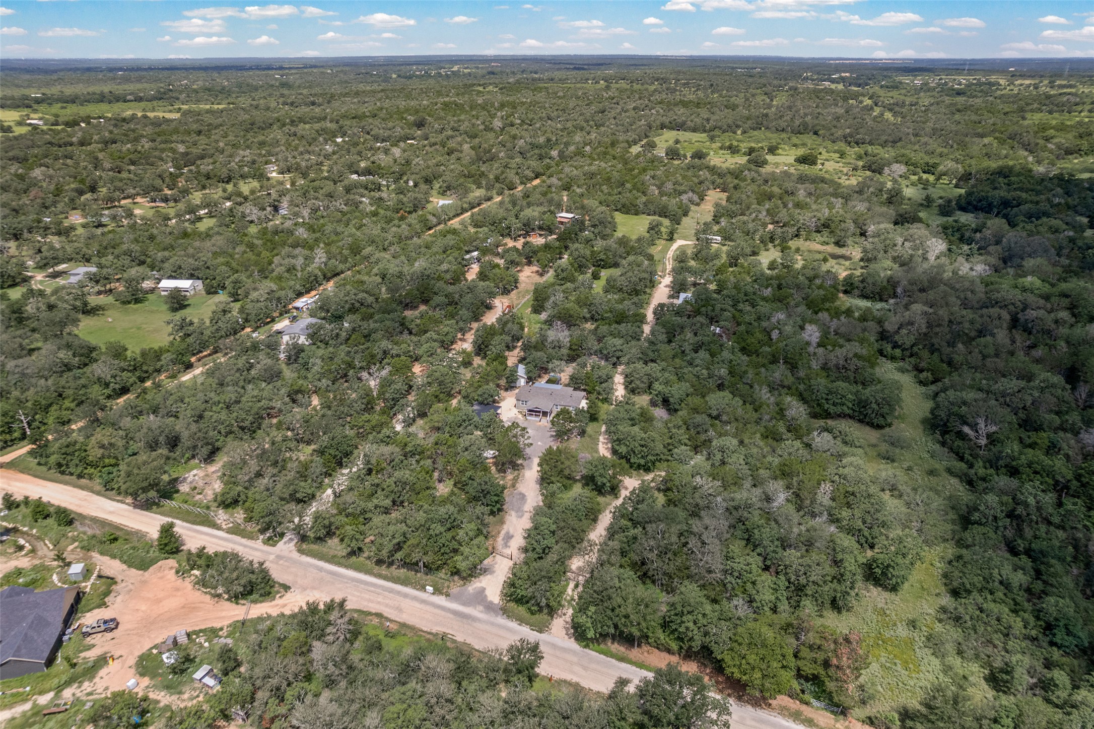 564 Boyd Road Red Rock, TX 78662 - Photo 8 of 25 An aerial panorama reveals a vast, tree-filled landscape with scattered residences.