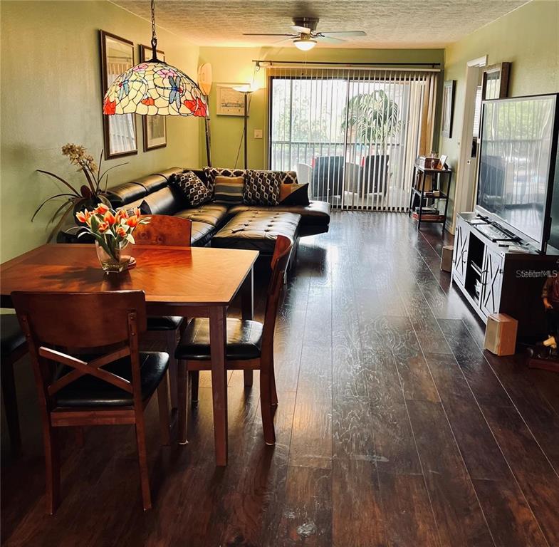 5640 Ferguson Court, Unit 2205 New Port Richey, FL 34652 - Photo 7 of 23 a living room with furniture a flat screen tv and a floor to ceiling window