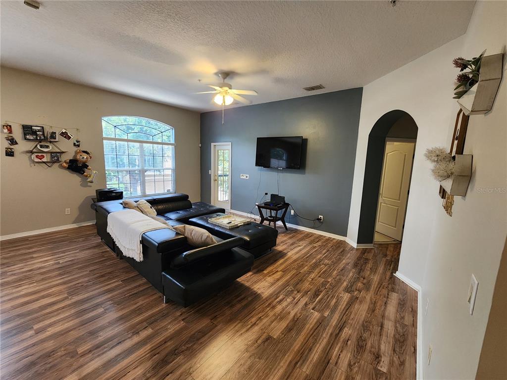 546 Climbing Ivy Court, Unit C Apopka, FL 32712 - Photo 11 of 26 a living room with furniture and a flat screen tv