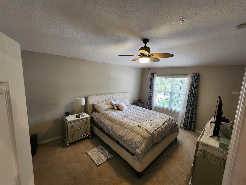 546 Climbing Ivy Court, Unit C Apopka, FL 32712 - Photo 15 of 26 a bedroom with a bed and a chandelier