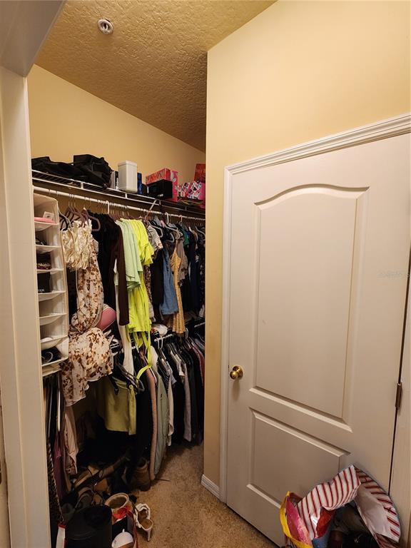 546 Climbing Ivy Court, Unit C Apopka, FL 32712 - Photo 16 of 26 a view of walk in closet with clothes and shoes