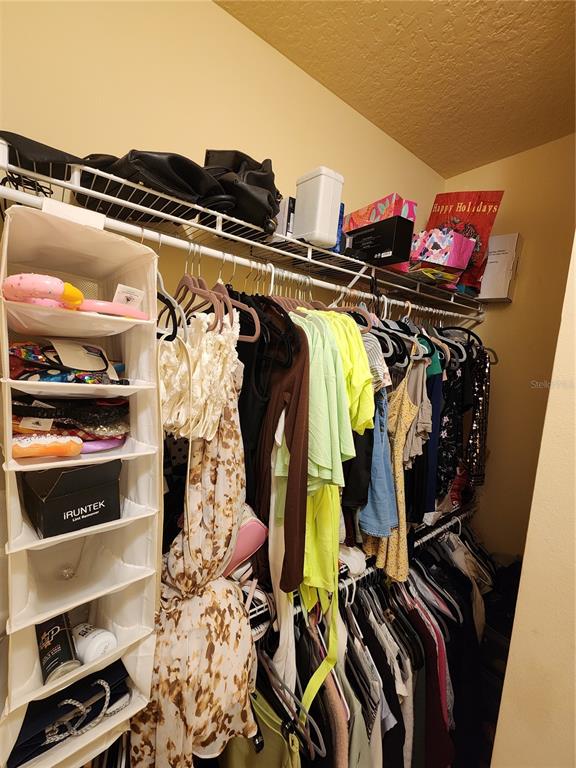 546 Climbing Ivy Court, Unit C Apopka, FL 32712 - Photo 17 of 26 a view of walk in closet with clothes and shoes