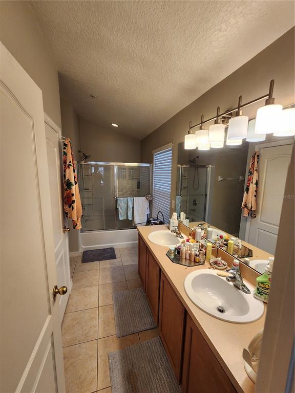 546 Climbing Ivy Court, Unit C Apopka, FL 32712 - Photo 19 of 26 a bathroom with a sink a large mirror and a shower