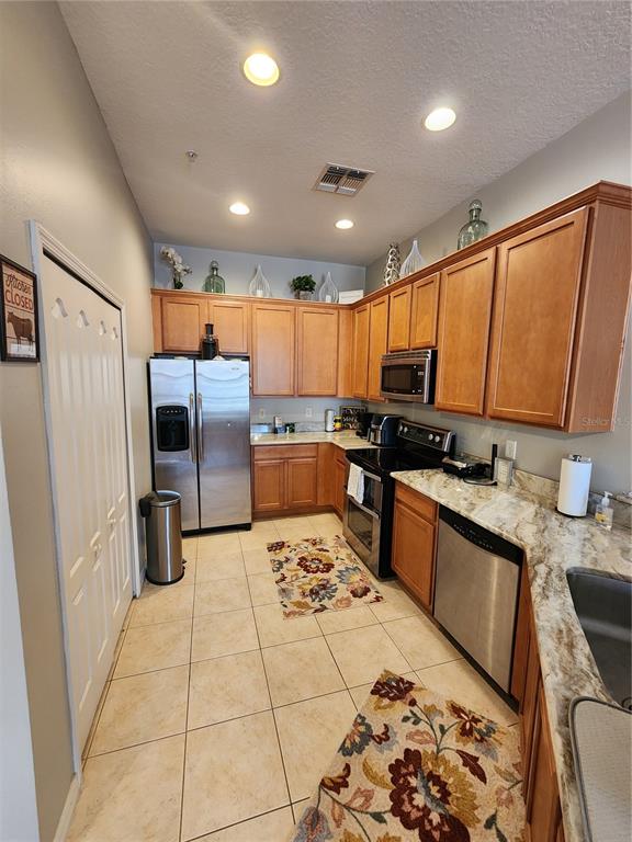 546 Climbing Ivy Court, Unit C Apopka, FL 32712 - Photo 7 of 26 a kitchen with stainless steel appliances granite countertop a refrigerator stove sink and dishwasher