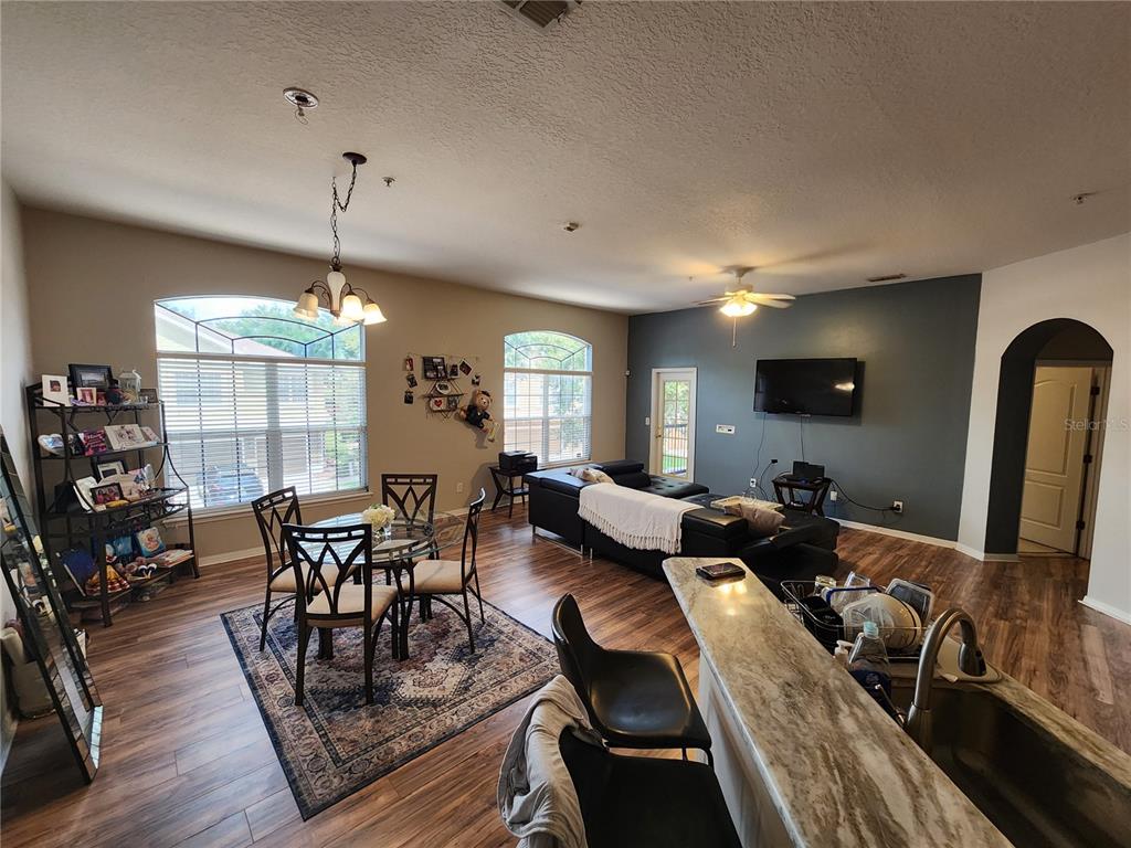546 Climbing Ivy Court, Unit C Apopka, FL 32712 - Photo 8 of 26 a living room with furniture a dining table and a large window