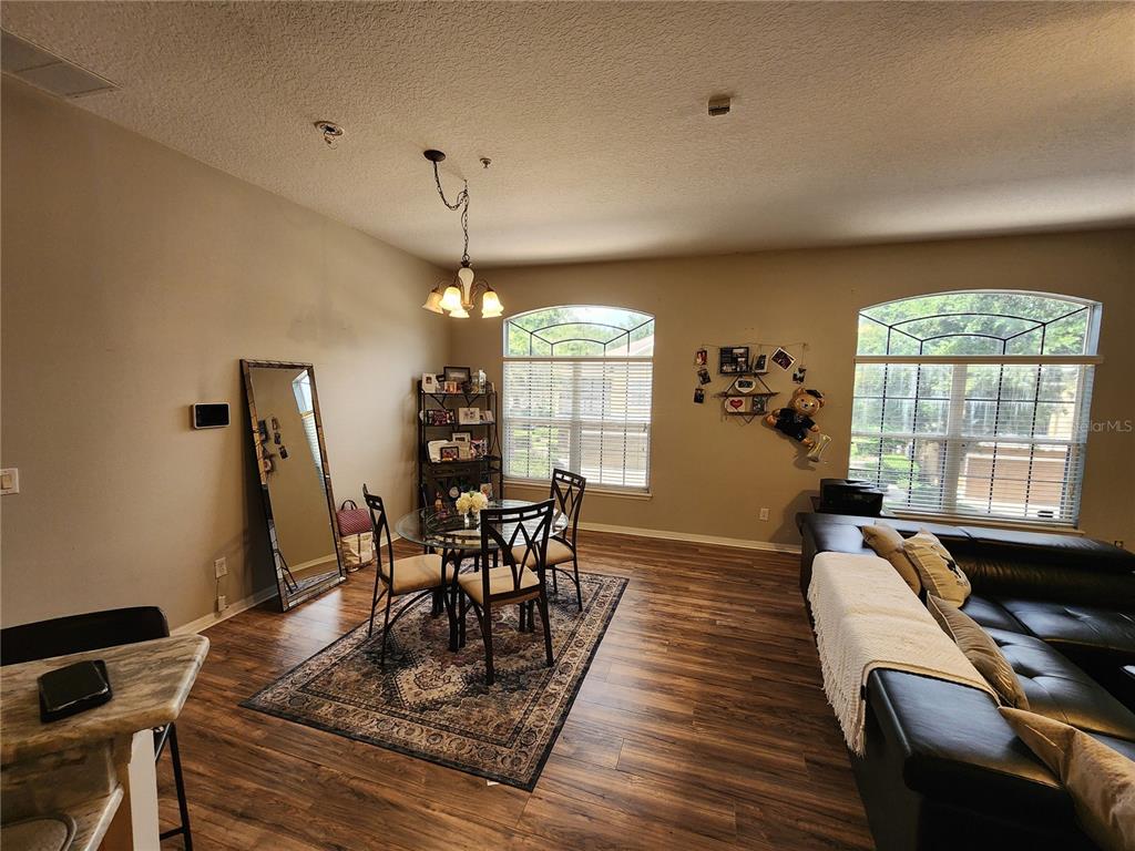 546 Climbing Ivy Court, Unit C Apopka, FL 32712 - Photo 10 of 26 a dining room with furniture a chandelier and wooden floor