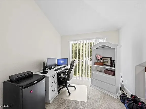 a view of a workspace with furniture and a window