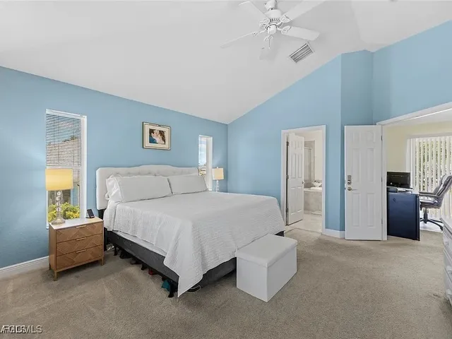 a spacious bedroom with a bed and a chandelier