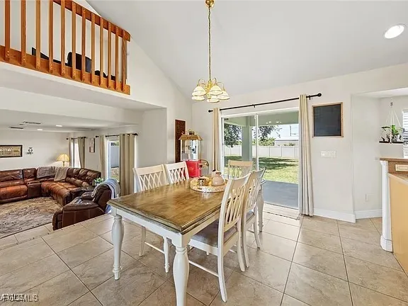 a dining room with furniture a chandelier and wooden floor