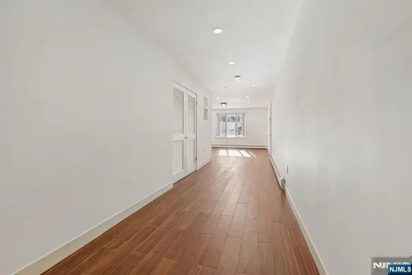 a view of an empty room with wooden floor