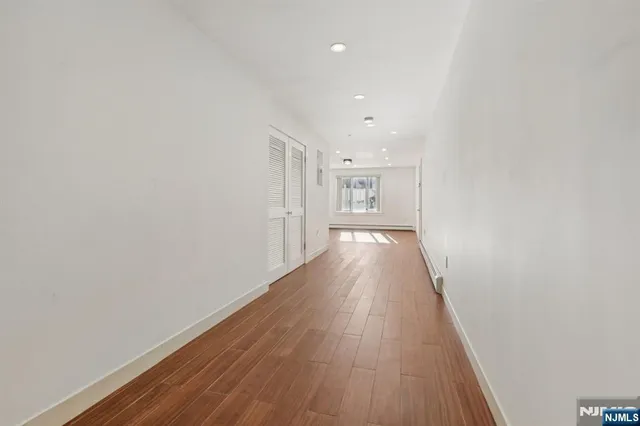 a view of an empty room with wooden floor