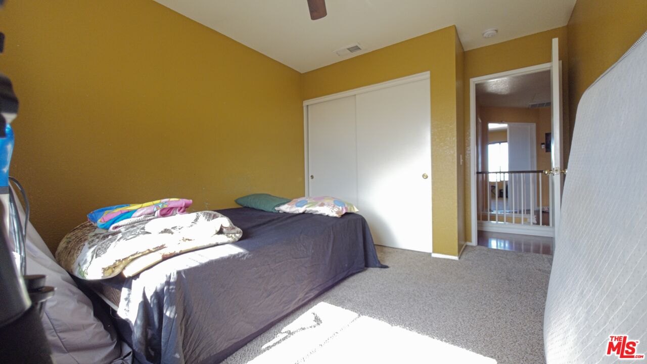 11532 Autumn Street Adelanto, CA 92301 - Photo 20 of 32 a bedroom with a bed and hallway