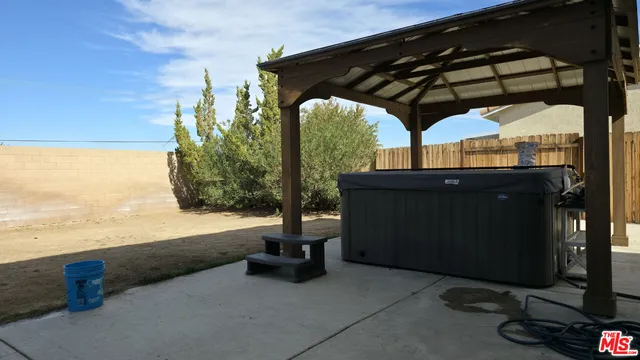 a view of patio with lawn chairs under an umbrella