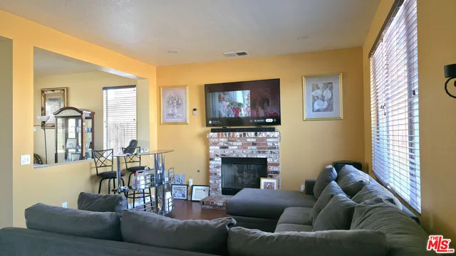 a living room with fireplace furniture and a flat screen tv