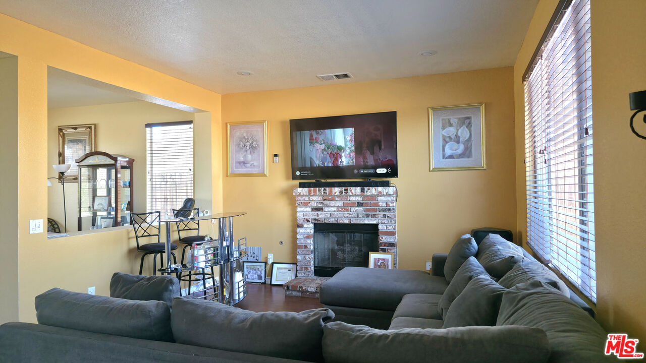 11532 Autumn Street Adelanto, CA 92301 - Photo 6 of 32 a living room with fireplace furniture and a flat screen tv