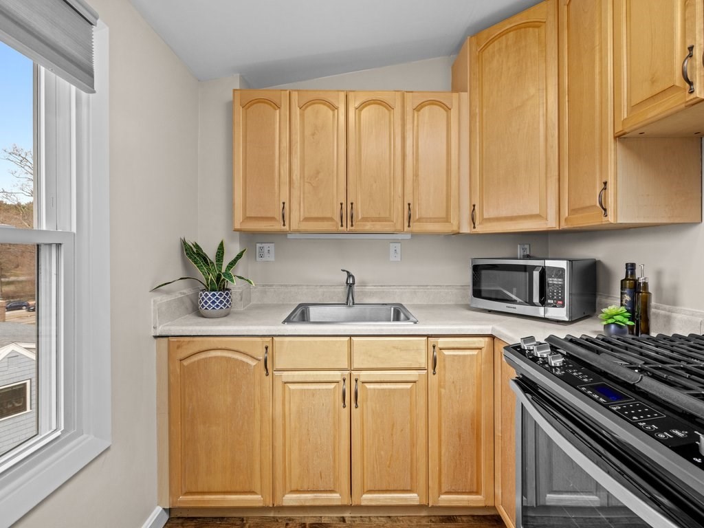 47 R Jamaica Street, Unit 3 Boston, MA 02130 - Photo 7 of 18 a kitchen with stainless steel appliances granite countertop a stove a sink and a white cabinets