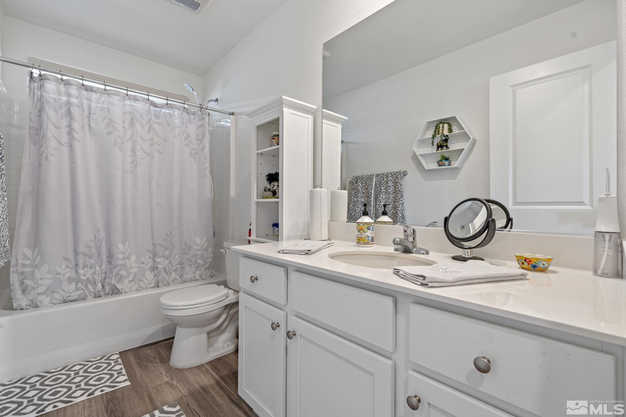 677 Mcgill Drive Reno, NV 89506 - Photo 13 of 29 a bathroom with a granite countertop sink a toilet and a shower