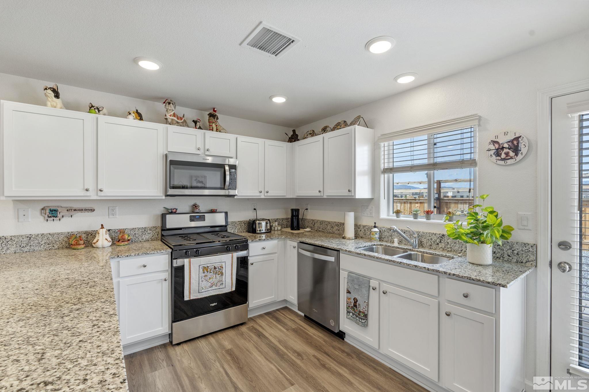 677 Mcgill Drive Reno, NV 89506 - Photo 22 of 29 a kitchen with granite countertop white cabinets and white appliances