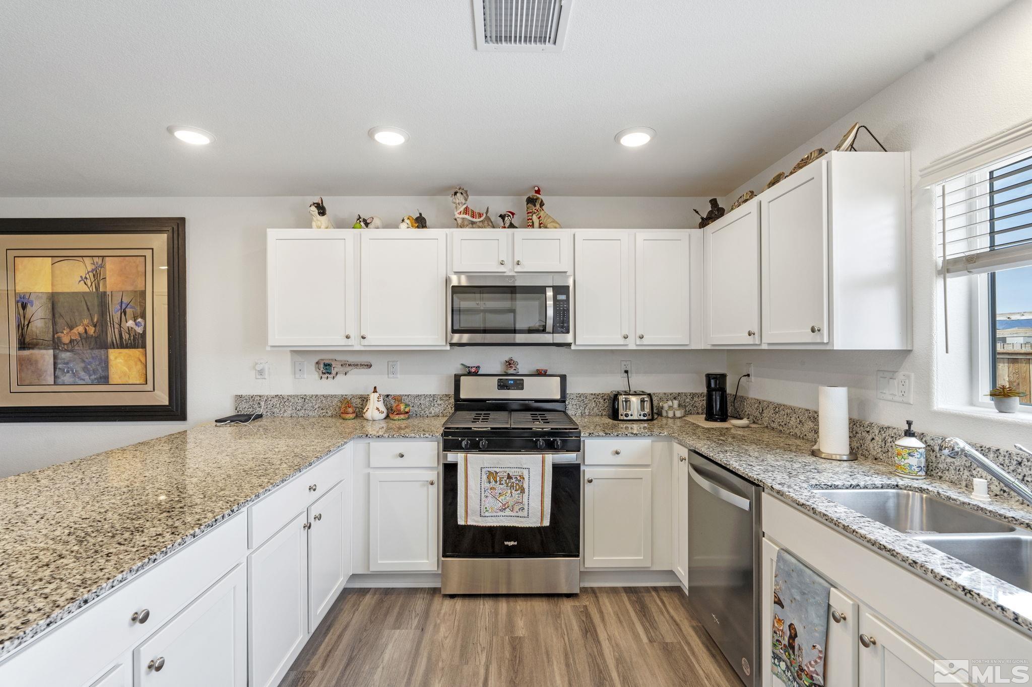 677 Mcgill Drive Reno, NV 89506 - Photo 23 of 29 a kitchen with granite countertop white cabinets and white appliances