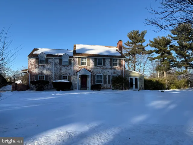 a front view of house with yard and trees in the background