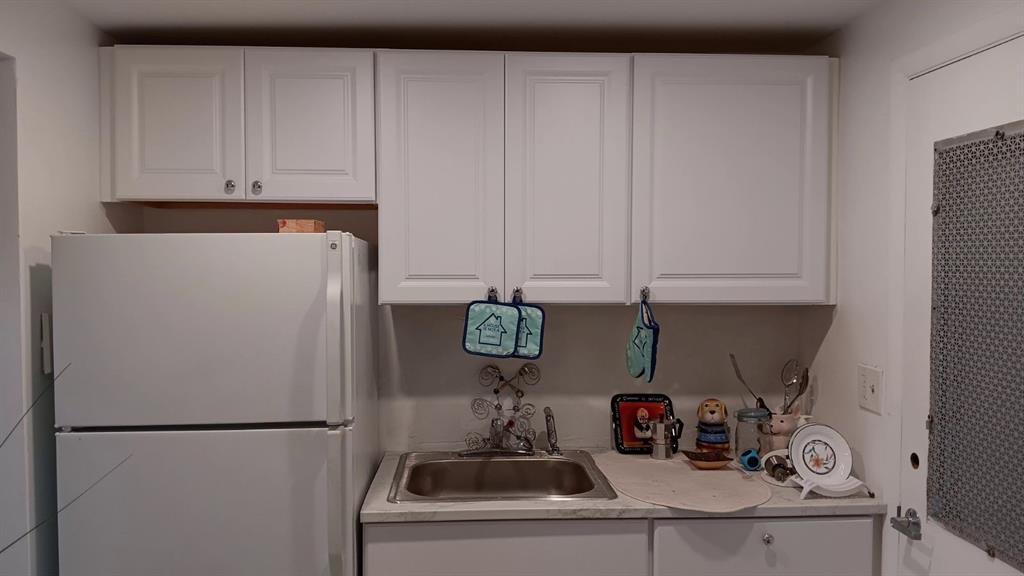 17090 Northeast 14th Avenue, Unit 211 North Miami Beach, FL 33162 - Photo 11 of 26 a kitchen with refrigerator and cabinets