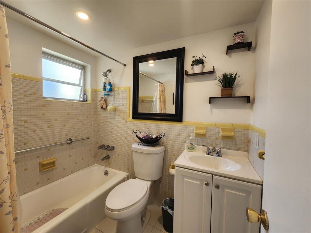 17090 Northeast 14th Avenue, Unit 211 North Miami Beach, FL 33162 - Photo 12 of 26 a bathroom with a toilet sink and mirror