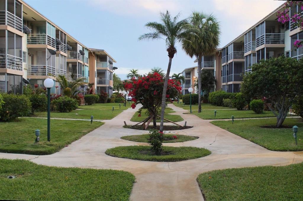 17090 Northeast 14th Avenue, Unit 211 North Miami Beach, FL 33162 - Photo 18 of 26 a front view of a building with garden and trees