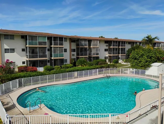 a view of a house with a backyard and swimming pool