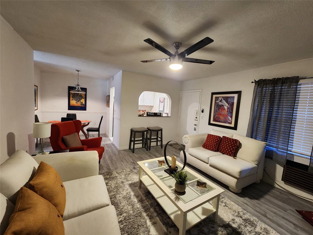 17090 Northeast 14th Avenue, Unit 211 North Miami Beach, FL 33162 - Photo 4 of 26 a living room with furniture a rug and a wall painting