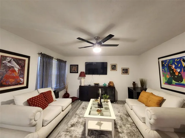 a living room with furniture a flat screen tv and a wall painting